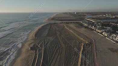 Drone footage of the shore of Newport Beach city on the coast of the Pacific Ocean at sunset, USA