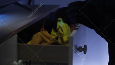 property theft, male thief in gloves looking for valuables and money, hands close-up