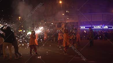 Barcelona, Spain - 20 January 2025: traditional catalan Correfoc, people dressed as devils with firecrackers, in slow motion