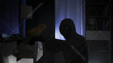 theft of someone elses property, a male offender in a balaclava is looking for valuables and money in other people