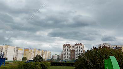 The wind before a hurricane in the city against the background of clouds in the sky and multi-story buildings in the