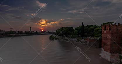 Cityscape view from Castelvecchio castle bridge. Sunset on the background, Adige river on the