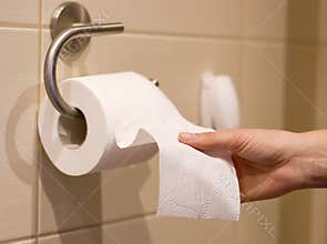 Hand reaches for toilet paper