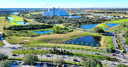 Cars driving on road surrounded by greenery and water ponds in Champions Gate, Florida