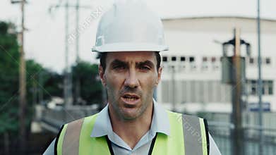 Portrait of man architect speaking with boss at construction site using webcam video call