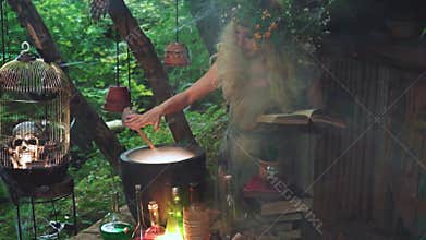 A good forest magician woman casts a spell on her potion.
