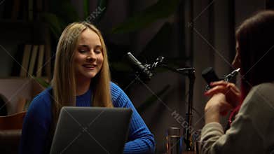 Two Influencers of women being interviewed in a loft-style podcast studio