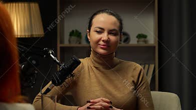 Two Influencers of women being interviewed in a loft-style podcast studio