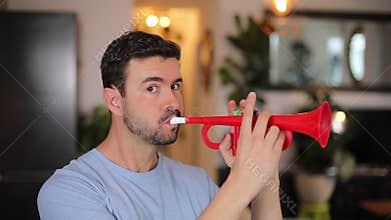 Funny man playing the trumpet at home during the night