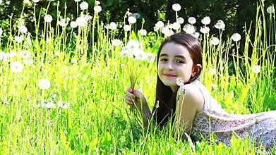 Little girl blowing dandelions