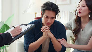 Young asian couple experiencing marriage counseling, wife comforting partner while talking with psychologist for mental health and