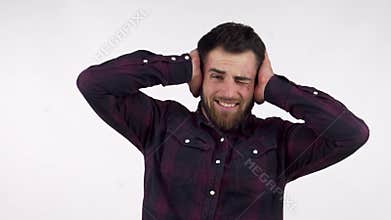 Bearded man covering his ears from overwhelming noise