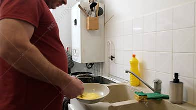 Man washing dishes in modern kitchen  domestic chore in progress