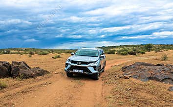 A gray Toyota Fortuner in the middle of the Namib Desert.