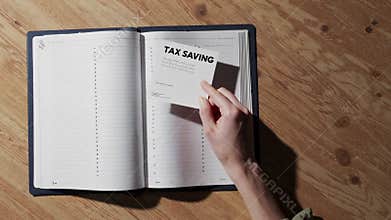 Accountant placing tax saving note on agenda