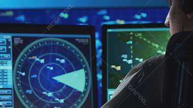 Professional air traffic controller in the control tower. Aircraft control officer works using radar, computer