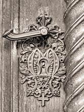 Vintage doorknob on antique door with cross