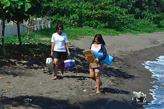 Two tired teenage girls walking on sandy beach path