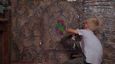 A little boy climbs through a small door in the wall in the quest room.