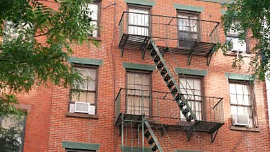 New York City building architecture, Manhattan. Residential house exterior. Red brick, fire escape.