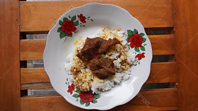 eating rendang in front of the house