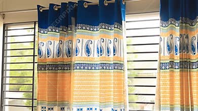 Modern cozy bedroom with colorful window decor. Bright vibrant curtain design. Airy organized living space