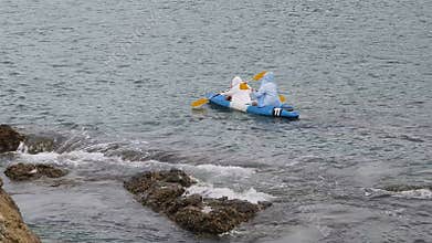 The young couple are happily navigating together in a light blue kayak with yellow paddles