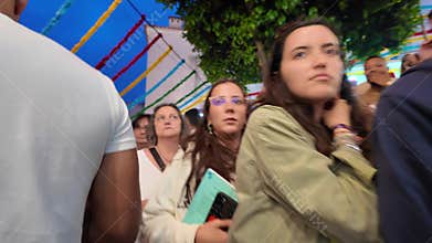 Crowds of people in Lisbon at night enjoying Saint Anthony festival with food and lights