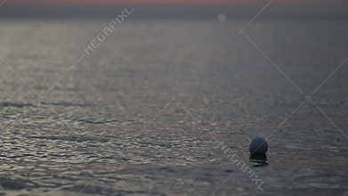 Seascape view in evening time with sea wave and orange sunset in background.