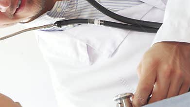 Doctor examines young girl’s lungs with a stethoscope and gives a thumbs up
