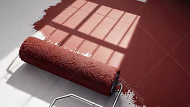 A paint roller lies on a floor with a partially painted area, capturing home improvement or renovation in progress.