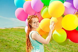 Luxury fashion woman with balloons in hand on the field against