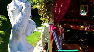 White statue of a woman with water jug in garden