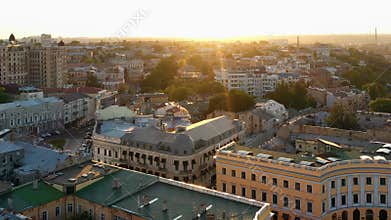 Aerial drone view of urban city scape with bright evening sunlight.