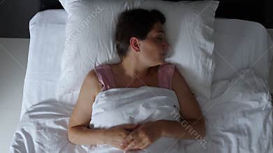 Woman tossing and turning in bed having trouble sleeping