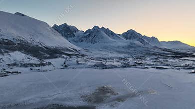 Drone flight in harsh Norwegian winter nature at sunset in the Lyngen Alps