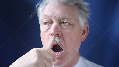 Older man brushing his teeth