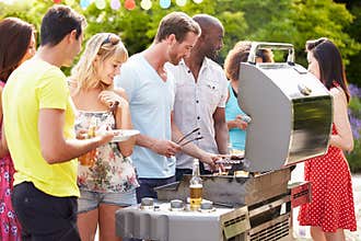 Group Of Friends Having Outdoor Barbeque At Home