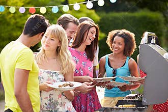 Group Of Friends Having Outdoor Barbeque At Home