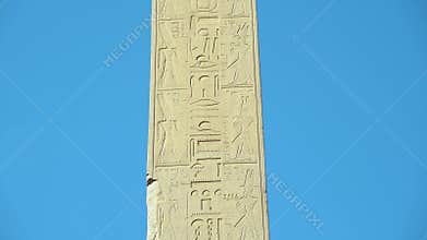 Egyptian Abelisk with Hieroglyphs on Blue Sky in Karnak