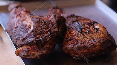 Closeup detailed shot of grilled chicken breasts in a metal tray, showcasing the cooked texture