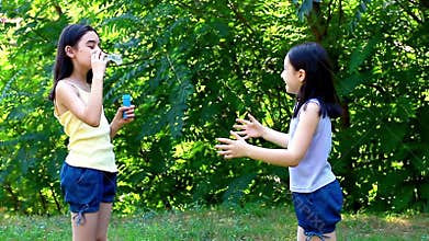 Little girls blowing bubbles