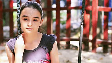 Sad preteen girl sitting on swing