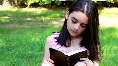 Young girl reading Holy Bible.