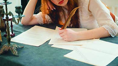 Girl fantasy princess sits at desk writes letter on sheet paper. woman writer 4k