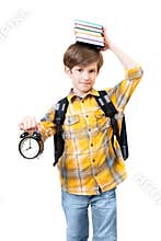 The boy with alarm clock and books