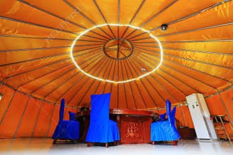 The table and chair are in the yurt