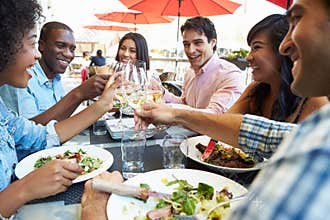Group Of Friends Enjoying Meal At Outdoor Restaurant