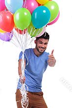 Man holding a bunch of balloons and making ok