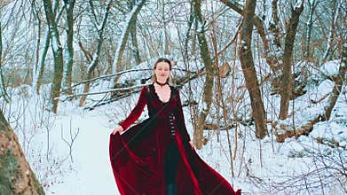 Fantasy woman queen walks in winter forest under snowfall. cold snowy nature